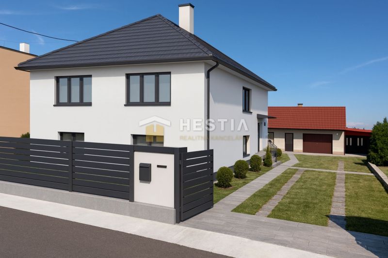 A family house in Šajdíkových Humence with an elegant fence and a landscaped garden.