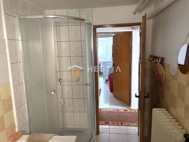 A bathroom in a family house with tiles and a shower corner.