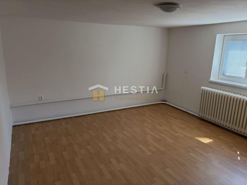 A room in a family house with a wooden decor floor and a radiator under the window.