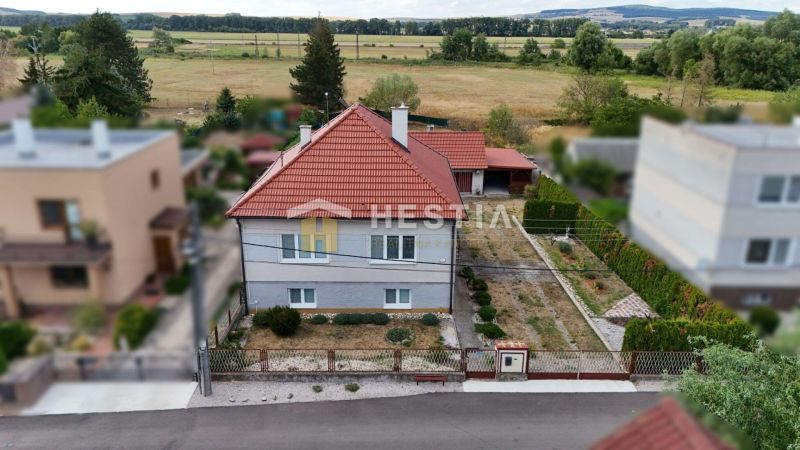 A family house in Šajdíkové Humence with a red roof and a landscaped garden.