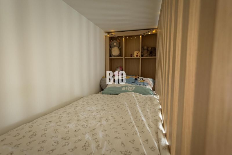 A children's bed with lights and toys in the cozy space of a 3-room apartment.