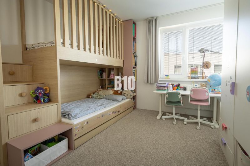 A children's room in a 3-room apartment with a bunk bed, a desk, and carpeted flooring.