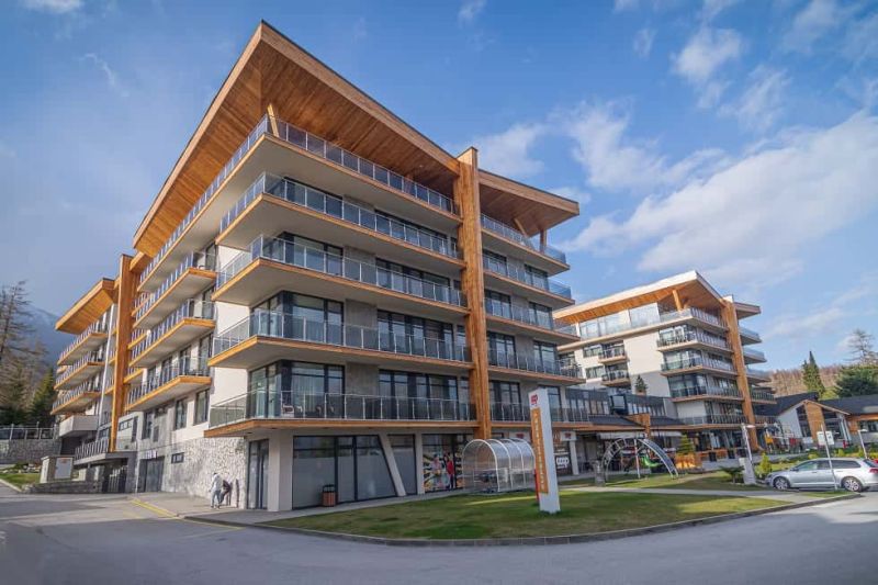 The building of the Recreational Apartment in Starý Smokovec with glass balconies and wooden decor.