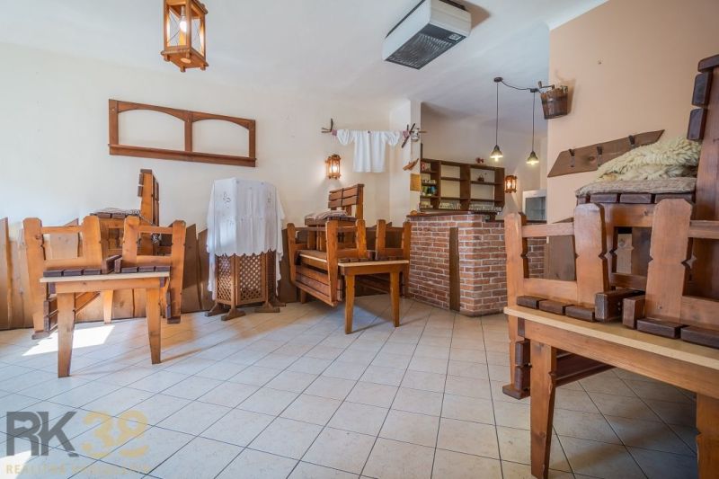 Gastro premises with wooden chairs and a brick bar, tiled floor.
