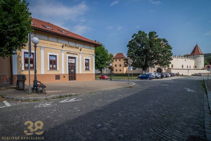 A restaurant on the Castle Square in Kežmarok with a view of historical buildings.