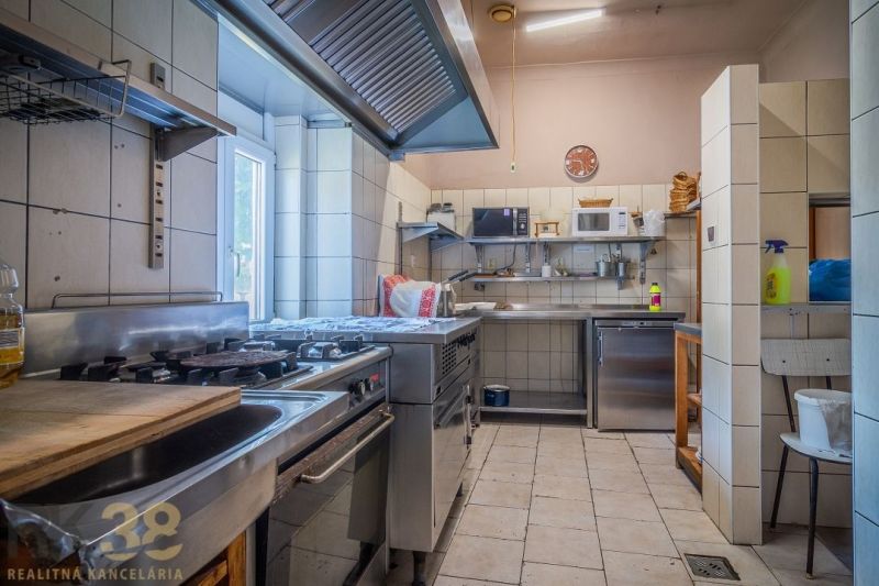 Professional kitchen with stainless steel equipment in catering spaces with ceramic tiles.