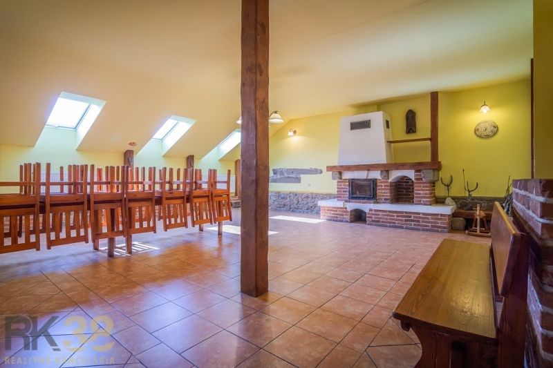 Gastro premises with a fireplace, floor with wooden decor, and chairs turned upside down.