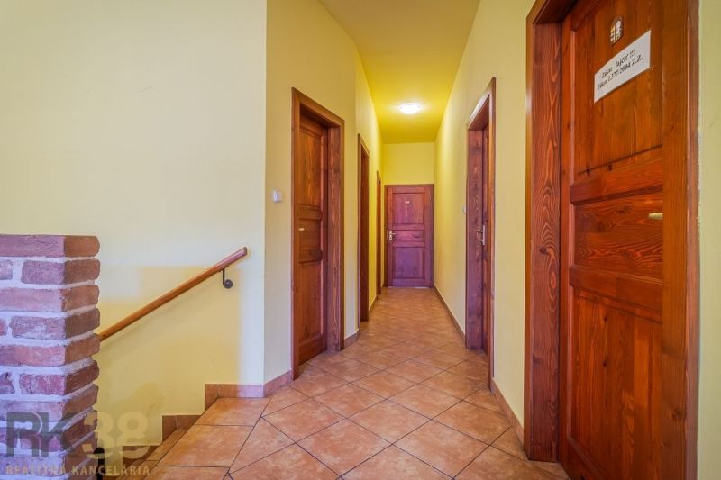 A corridor with multiple doors and a wooden decor floor in dining premises.