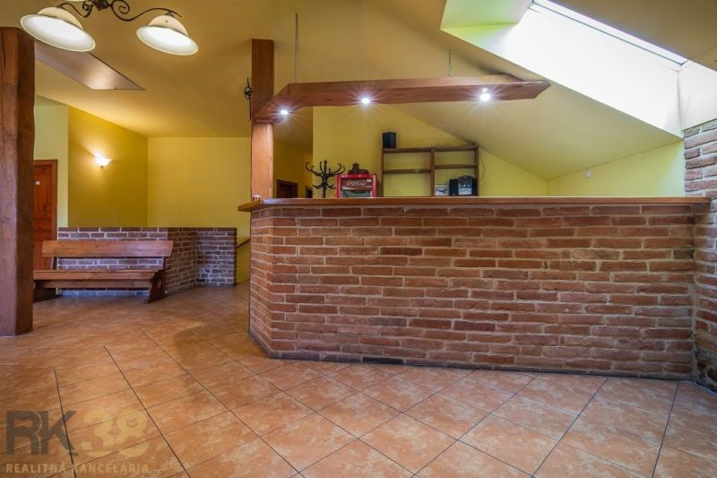 Brick bar counter in a gastro space with a wood-patterned floor and wooden elements.