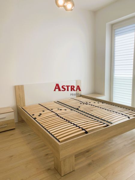 A bedroom with a wooden bed, nightstands, and a floor with a wood decor.