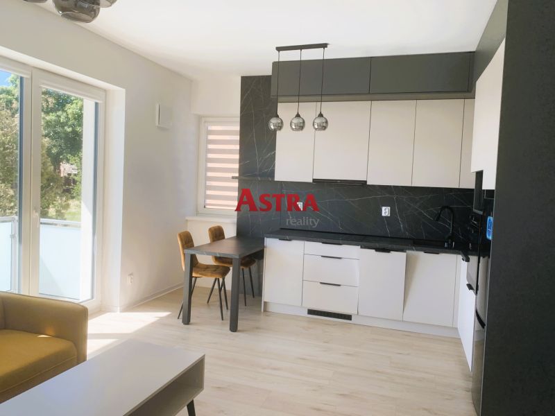 A bright kitchen with a wood-patterned floor in a 3-room apartment.