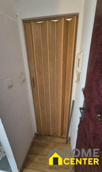 A hidden space with sliding doors and a wooden decor floor in a studio apartment.