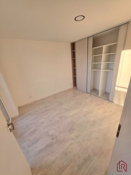 A room with a wooden decor floor and a built-in wardrobe in a 2-room apartment.