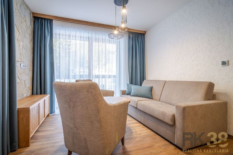 Recreational apartment with a comfortable sofa, armchair, and wooden decor flooring.