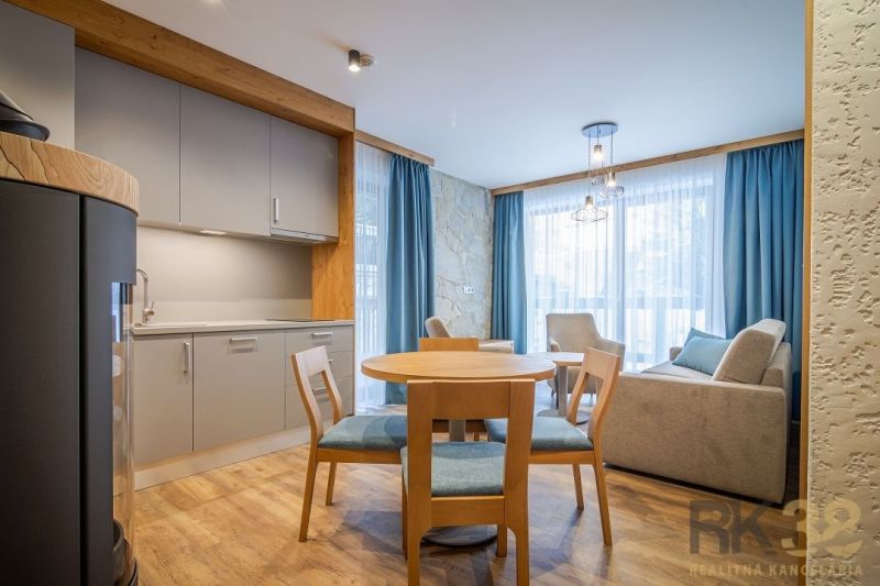 Recreational apartment with wood-decor flooring, kitchenette, dining table, and living area.