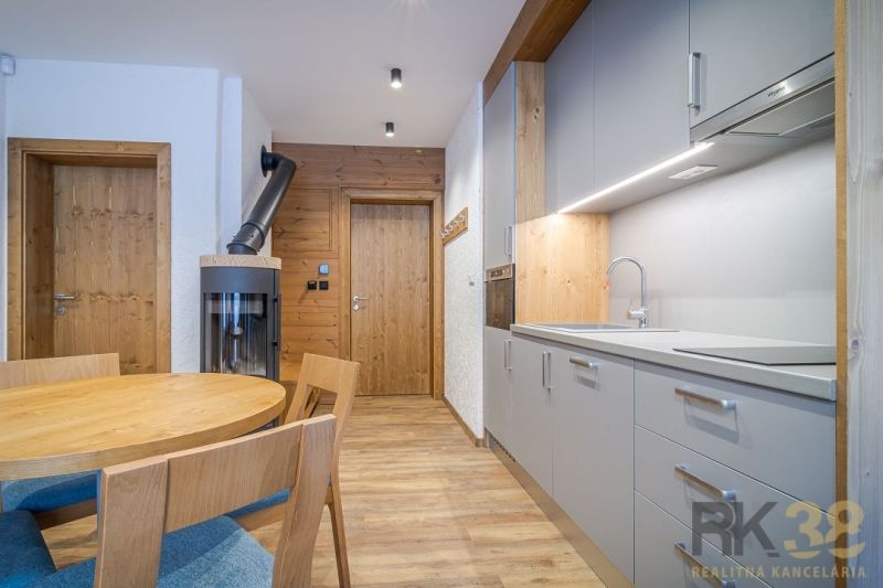 The kitchen of a recreational apartment with a modern kitchenette, dining table, and floor with a wood decor.