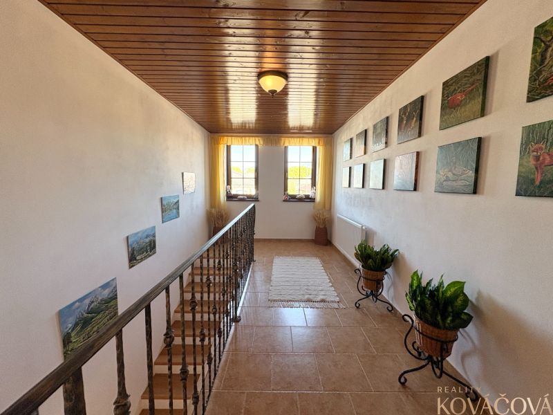 A hallway with decorations and flowers, a floor with a wooden decor, a family house.