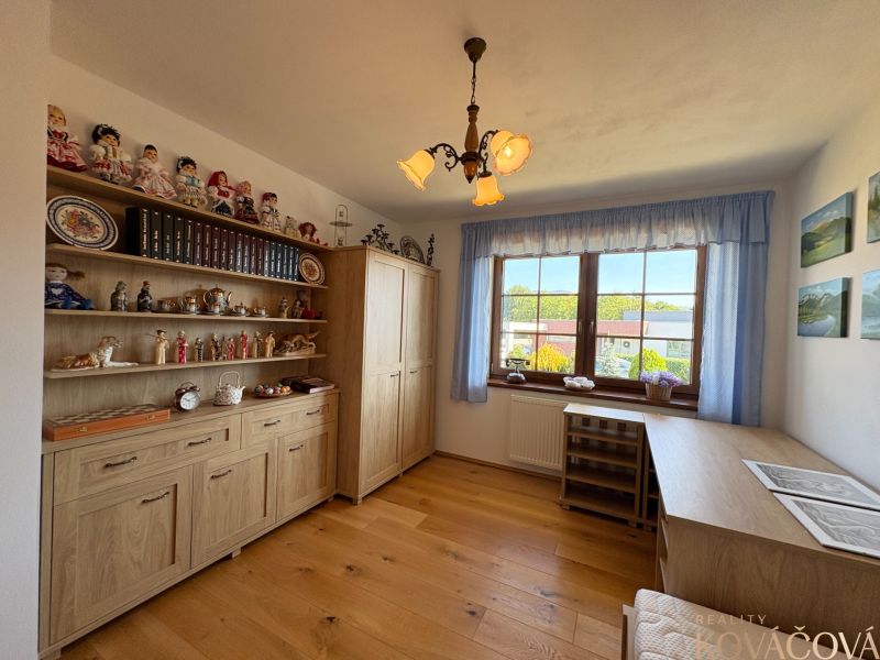 A room in a family house with shelves full of decorations and a floor with a wooden decor.