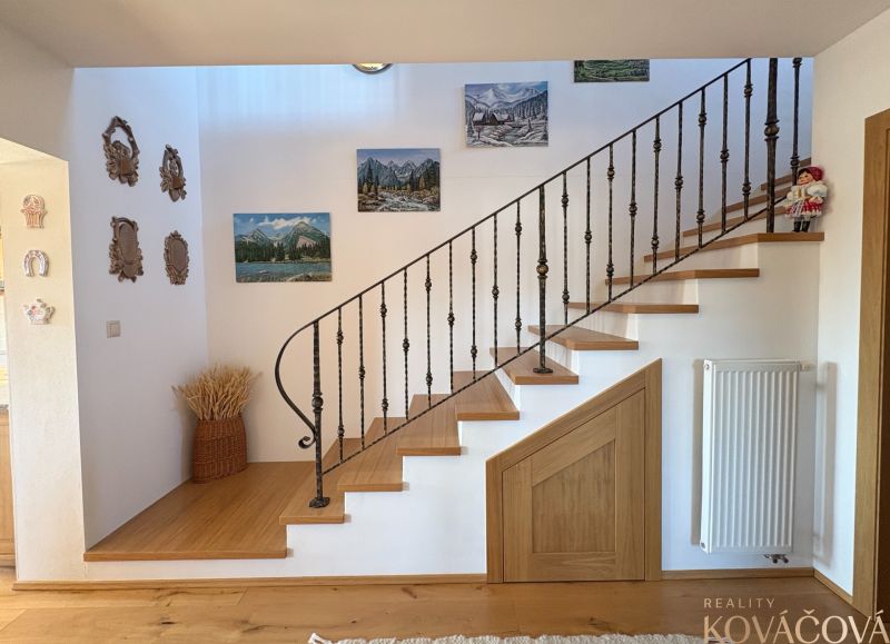Interior of a family house with a wooden staircase and wall decorations.
