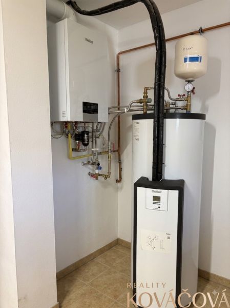 Boilers with piping in a family house, on a floor with ceramic tiles.