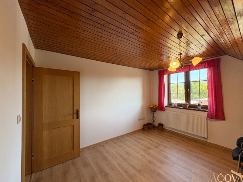 A room with a wooden decor floor and wooden paneling in a family house.