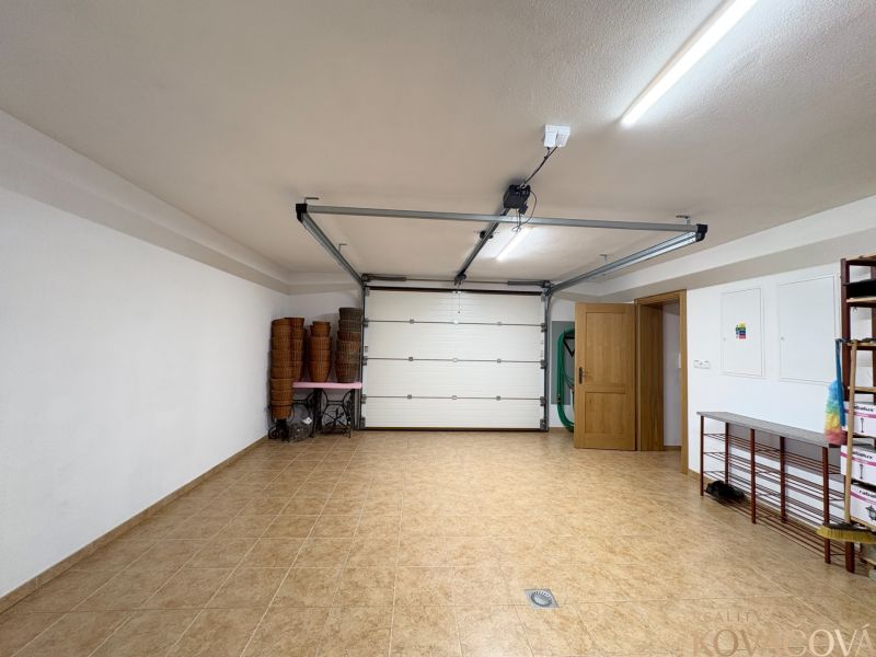 A garage with opening doors and brown tiles in a family house.
