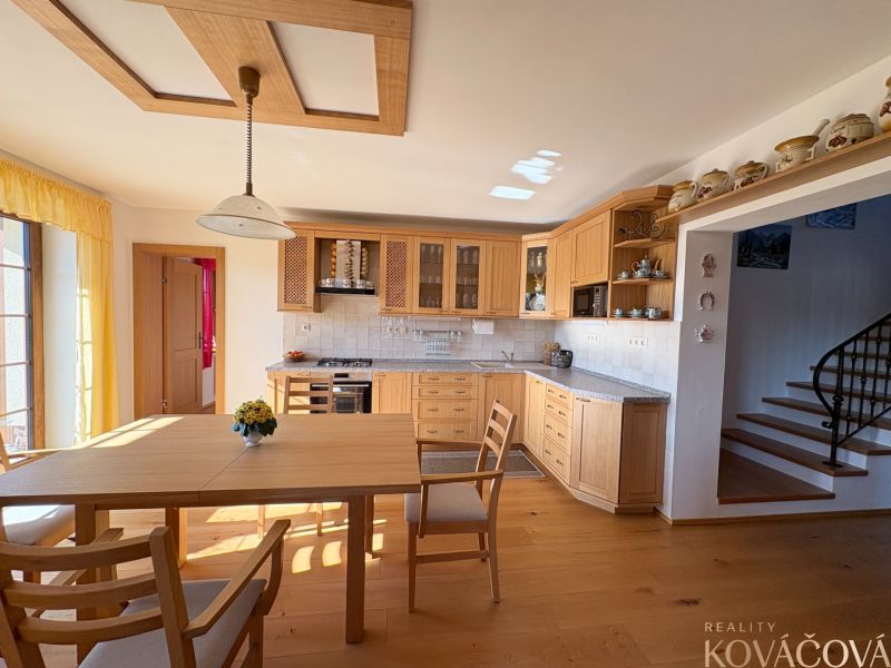 A kitchen in a family house with wooden cabinets and a floor with a wooden decor.