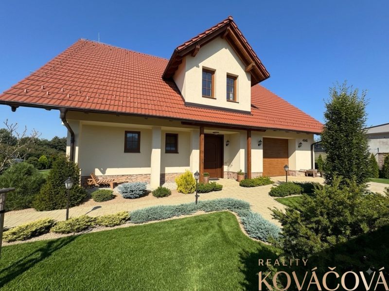 A family house in Trenčianska Turná with a red roof and a landscaped garden.