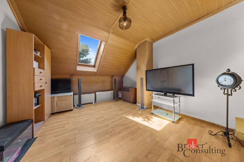 Attic living room with wooden floor decor and a skylight in a family house.