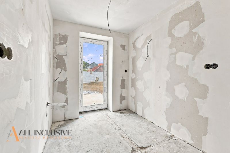 Unfinished room in a family house with drywall walls and a window.