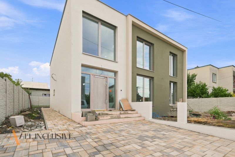 A family house in Holice with a light facade and a paved courtyard.