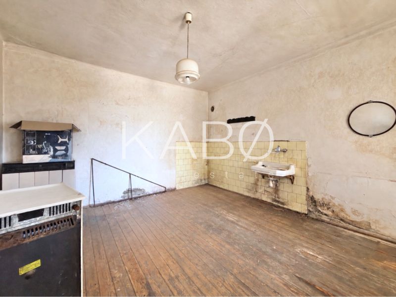 Interior of a family house with a wooden decor floor, old furniture, and a sink.