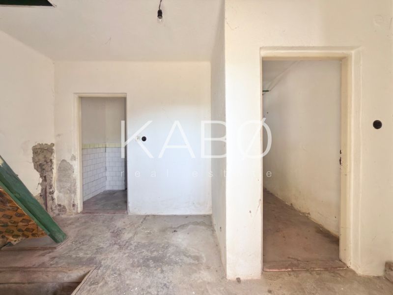 Unfurnished interior of a family house with older walls and doors.