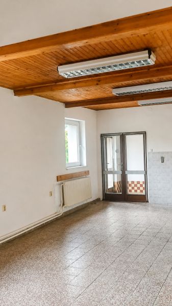 Interior of a family house with a wooden ceiling and ceramic floor.
