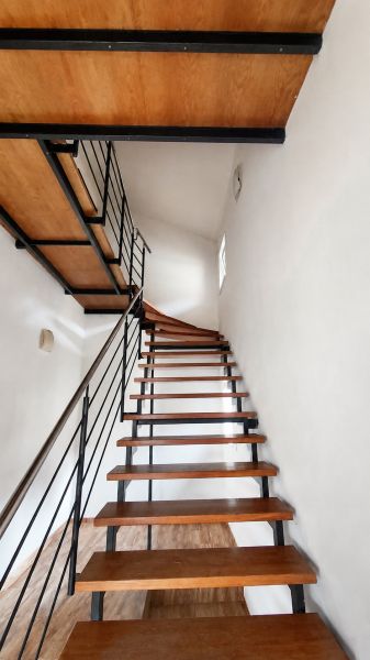 A staircase with a metal railing and steps with a wooden decor in a family house.