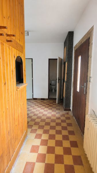 A hallway in a family house with checkered tiles and wooden wall panels.