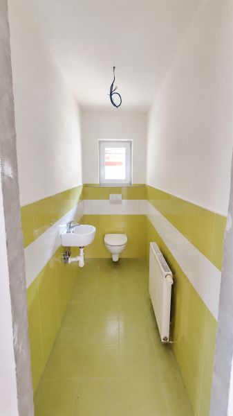 A bathroom in a family house with ceramic tiles and sanitary ware.