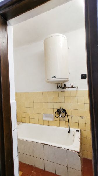 A bathroom in a family house with a bathtub and a gas boiler.