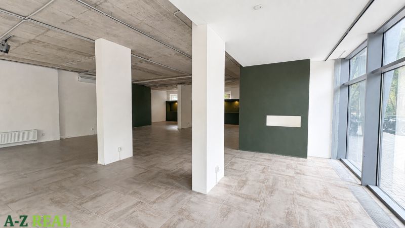 Spacious commercial spaces with large windows and concrete ceiling.