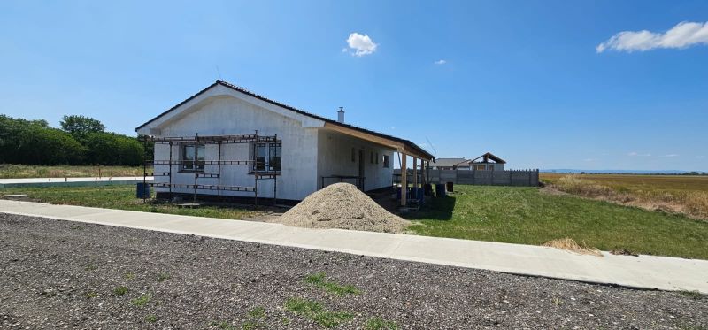 A family house in Bellova Ves with facade scaffolding and a pile of sand in the yard.