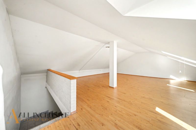 Attic interior with wooden decor flooring, suitable for residential properties.