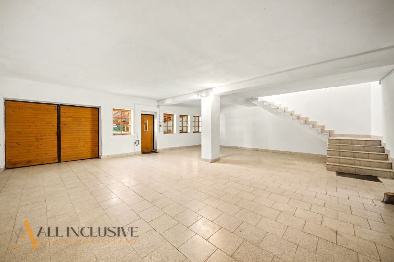 Spacious room with tiles and wooden doors, suitable for residential land.