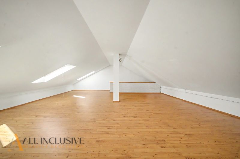 Attic space with a wooden decor floor and skylights. Plots - housing.