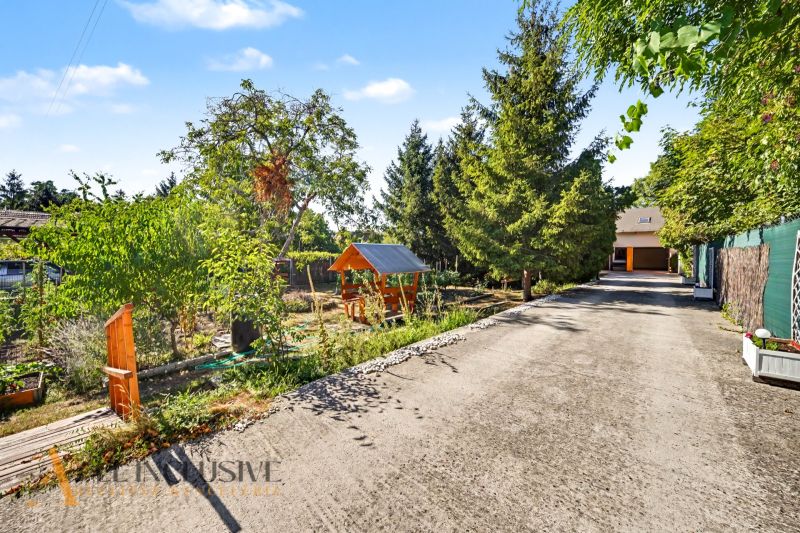 A reinforced driveway surrounded by greenery and a children's playground, an ideal location for living in Pezinok.