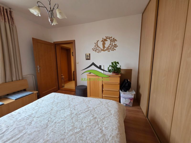 Bedroom in a 3-room apartment with a wardrobe and a wooden decor floor.