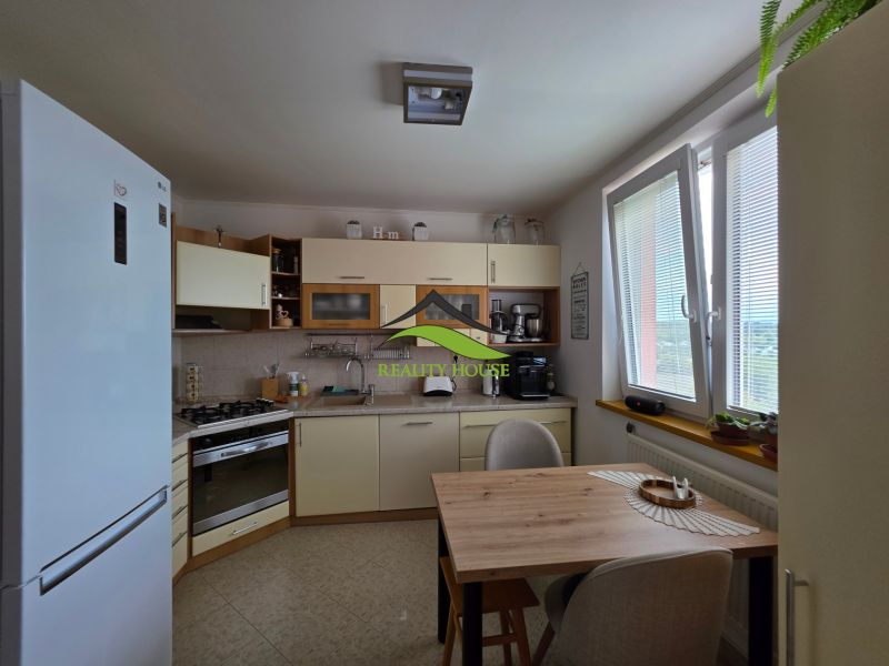 Kitchen in a 3-room apartment with a dining table and appliances.