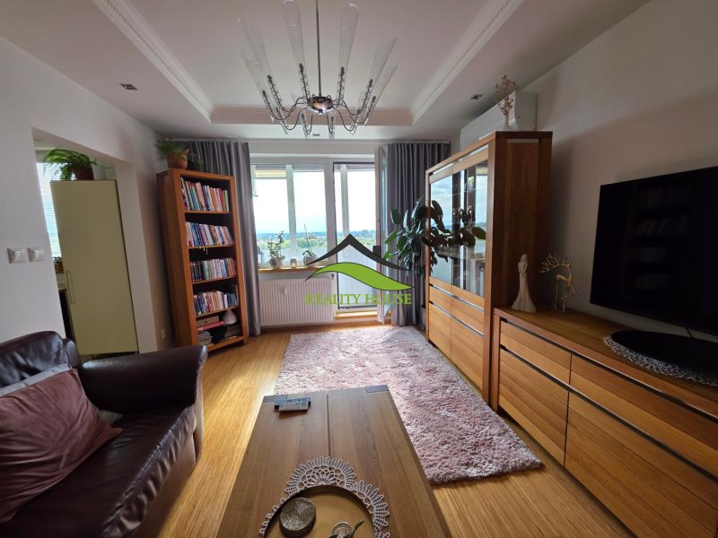 Living room in a 3-room apartment with a wooden decor floor and comfortable seating.