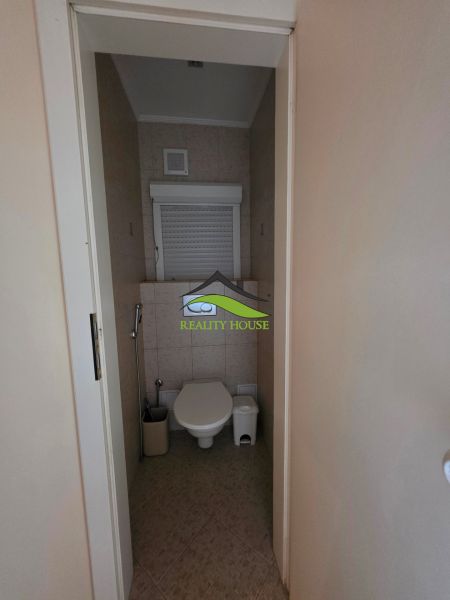 A toilet with light ceramic tiles in a 3-room apartment.