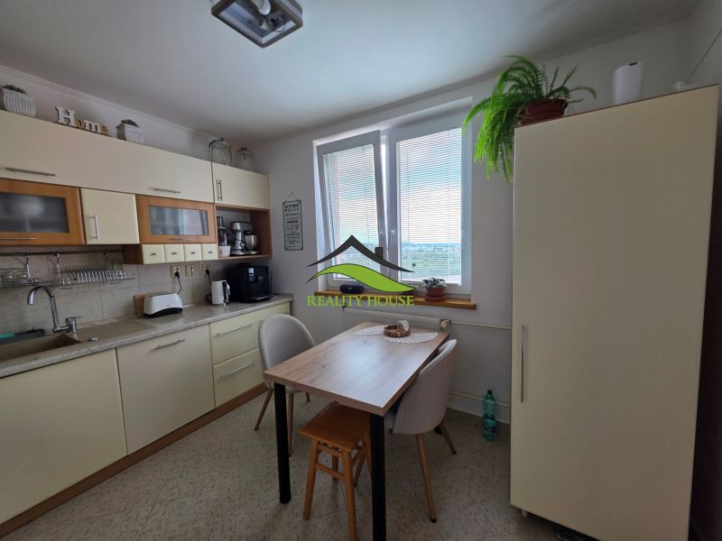 A kitchen in a 3-room apartment with simple furniture and natural decorations.
