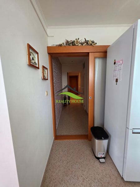 A hallway in a 3-room apartment with tiles and a decoration on the wall.